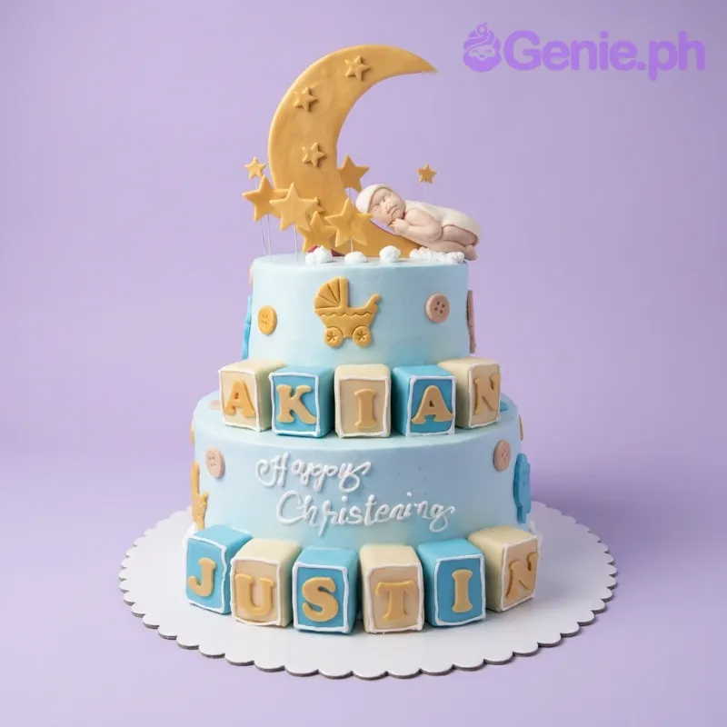 Light blue 2-tier christening cake with a sleeping baby on a crescent moon, yellow stars, and name blocks for Akian Justin. Light blue 2-tier christening cake with a sleeping baby on a crescent moon, yellow stars, and name blocks for Akian Justin.