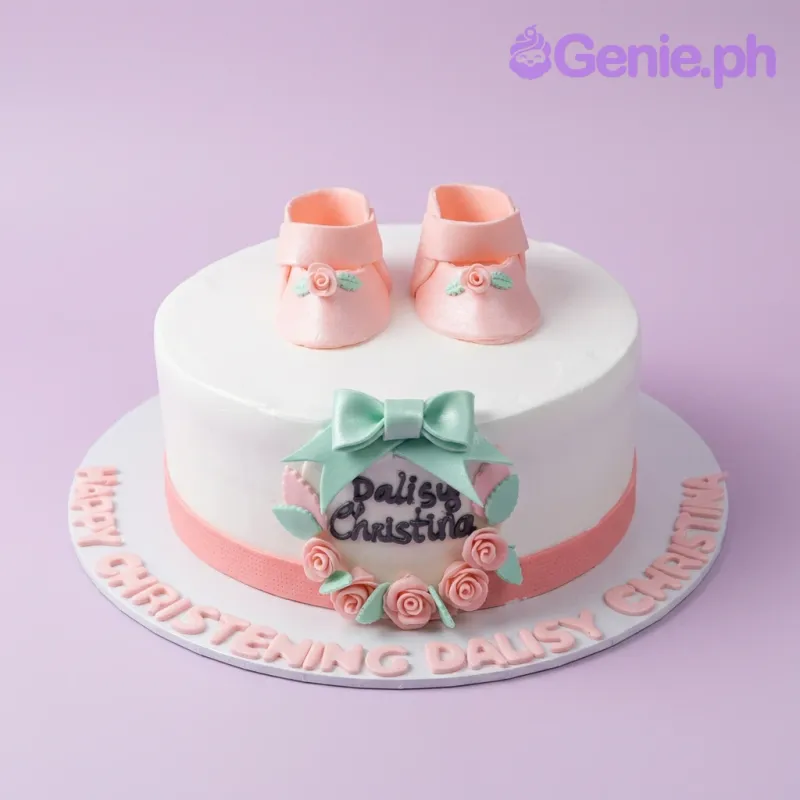 White round christening cake with pink fondant baby shoes, a mint green bow, and pink roses on a white base board. White round christening cake with pink fondant baby shoes, a mint green bow, and pink roses on a white base board.