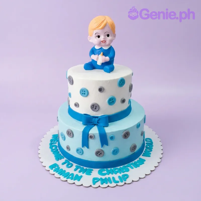 Two-tier blue and white christening cake with a baby boy topper and button decorations. Two-tier blue and white christening cake with a baby boy topper and button decorations.