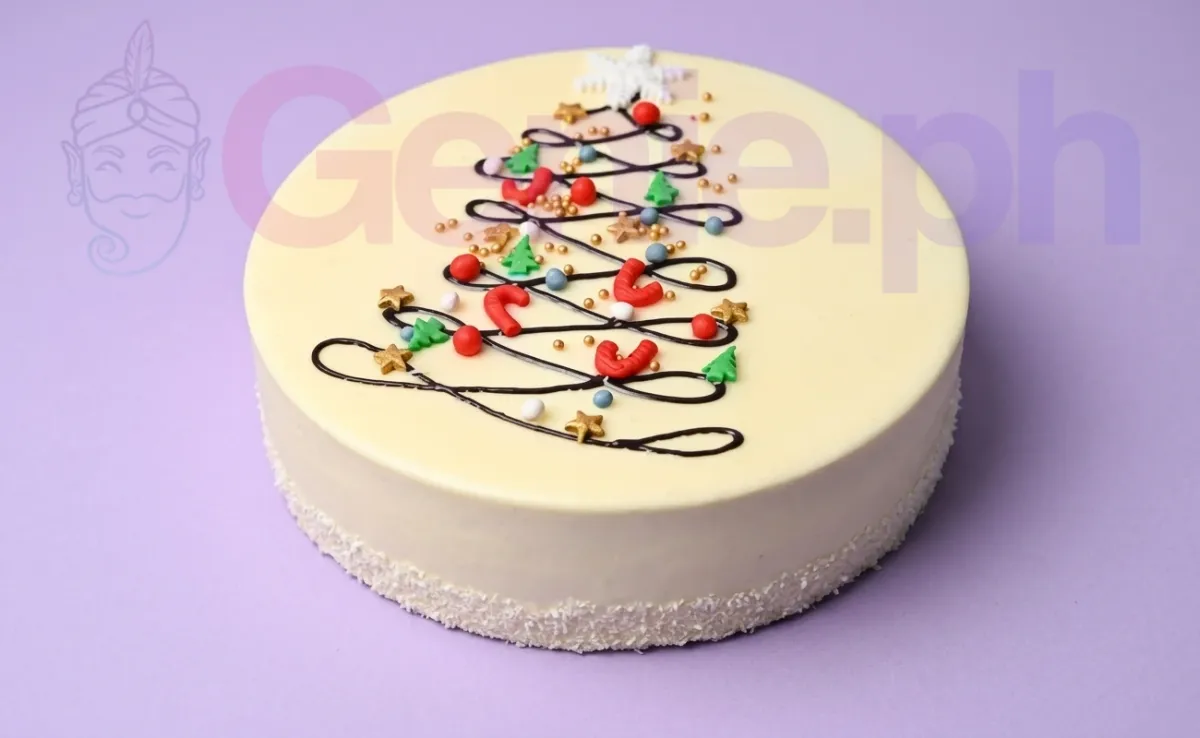 A white 1 Tier Christmas Tree cake with a piped chocolate tree, colorful ornaments, gold stars, and a coconut flake border. A white 1 Tier Christmas Tree cake with a piped chocolate tree, colorful ornaments, gold stars, and a coconut flake border.