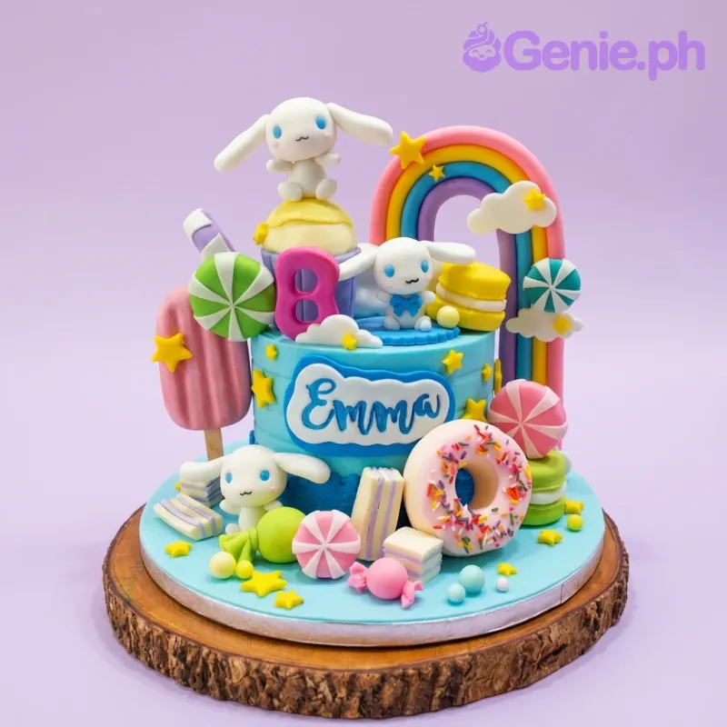 A vibrant blue fondant cake themed around Cinnamoroll, featuring characters, a rainbow, a donut, and candy decorations. A vibrant blue fondant cake themed around Cinnamoroll, featuring characters, a rainbow, a donut, and candy decorations.