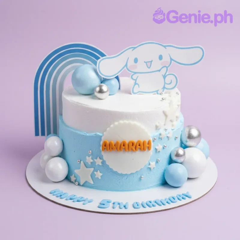 A white and light blue 1 Tier cake themed around Cinnamoroll, featuring a Cinnamoroll cutout, blue rainbow, plastic balls, and white stars. A white and light blue 1 Tier cake themed around Cinnamoroll, featuring a Cinnamoroll cutout, blue rainbow, plastic balls, and white stars.