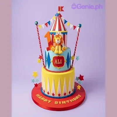 Yellow and blue 2-tier circus themed cake with a lion figurine and tent top Yellow and blue 2-tier circus themed cake with a lion figurine and tent top