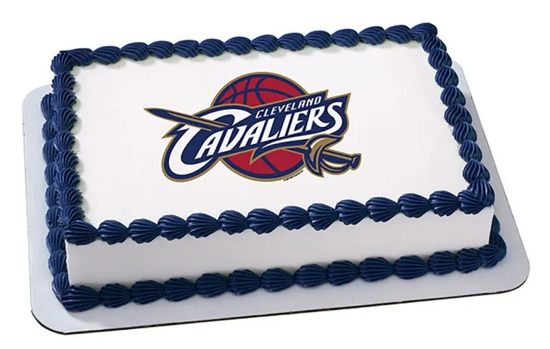 A white and navy blue rectangle cake themed around Cleveland Cavaliers, featuring a Cleveland Cavaliers logo printout and navy blue shell borders. A white and navy blue rectangle cake themed around Cleveland Cavaliers, featuring a Cleveland Cavaliers logo printout and navy blue shell borders.