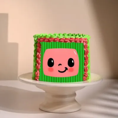 Light green 1-tier cake with soft icing, Cocomelon character printout, and pink piped frame Light green 1-tier cake with soft icing, Cocomelon character printout, and pink piped frame