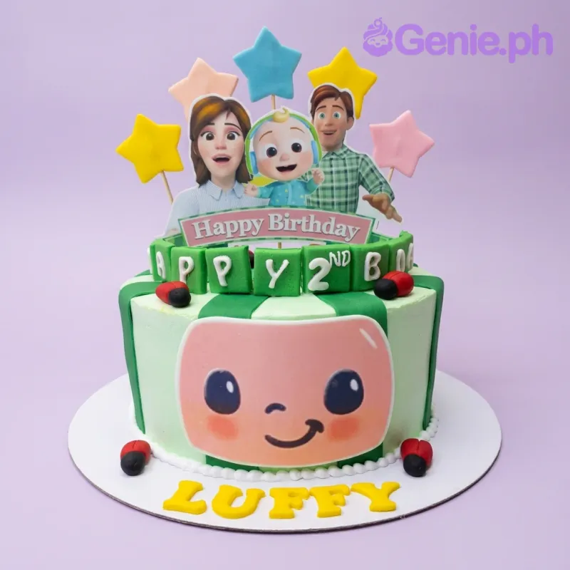 Cocomelon themed birthday cake with green stripes, ladybugs, and character printouts for a 2nd birthday. Cocomelon themed birthday cake with green stripes, ladybugs, and character printouts for a 2nd birthday.