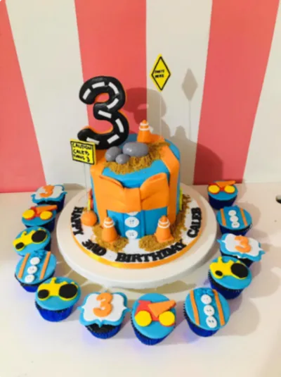 Vibrant orange 1-tier fondant cake with a construction cars theme, a black number three topper, and traffic cones Vibrant orange 1-tier fondant cake with a construction cars theme, a black number three topper, and traffic cones