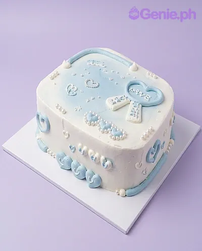 Light blue and white square cake with piped icing hearts, bows, and a central frame message Light blue and white square cake with piped icing hearts, bows, and a central frame message