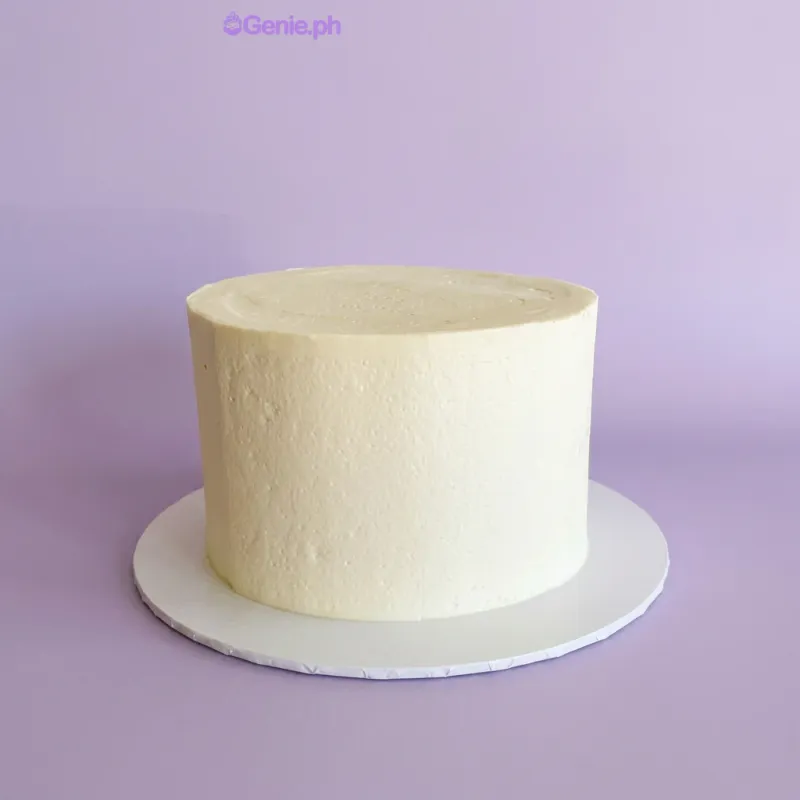 White single-tier minimalist cake on a white cake board White single-tier minimalist cake on a white cake board