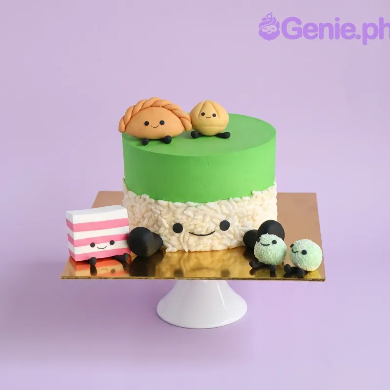 Green and beige 1-tier cake with cute edible character toppers and a piped face on the side Green and beige 1-tier cake with cute edible character toppers and a piped face on the side