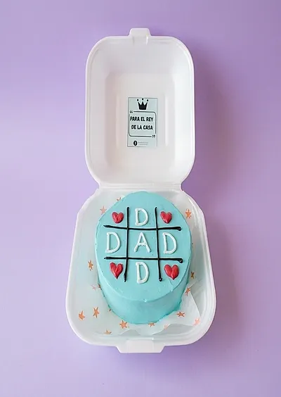 Light blue bento cake for Father's Day featuring a tic-tac-toe game design with 'DAD' and red hearts. Light blue bento cake for Father's Day featuring a tic-tac-toe game design with 'DAD' and red hearts.