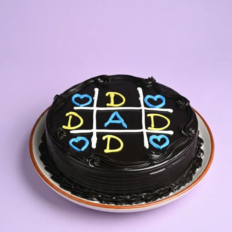 Black minimalist chocolate cake for Dad featuring a blue and yellow tic-tac-toe game design with hearts and letters. Black minimalist chocolate cake for Dad featuring a blue and yellow tic-tac-toe game design with hearts and letters.