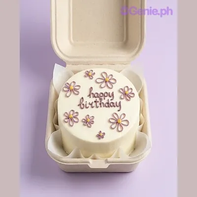 White bento cake with purple piped daisy flowers and happy birthday message White bento cake with purple piped daisy flowers and happy birthday message