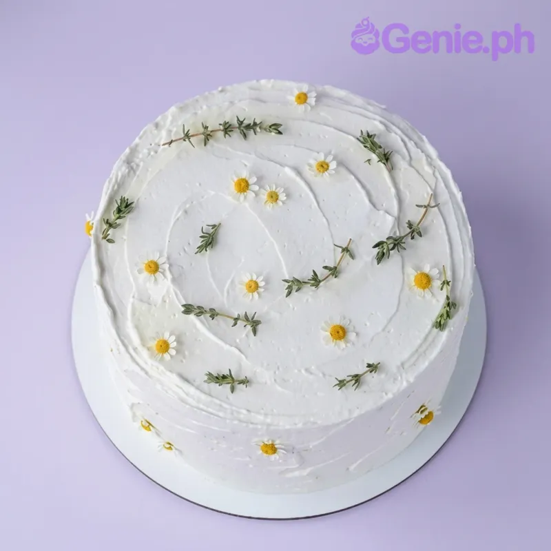 A white 1-tier Daisy Minimalist cake, featuring white edible daisies, green herb sprigs, and a textured icing finish. A white 1-tier Daisy Minimalist cake, featuring white edible daisies, green herb sprigs, and a textured icing finish.