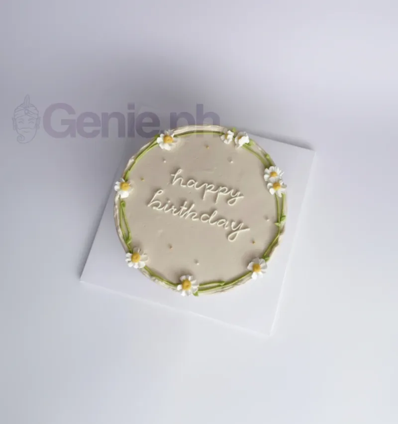 A white 1-Tier Daisy Minimalist cake, with piped daisies, green stems, 'happy birthday' message, and gold pearls. A white 1-Tier Daisy Minimalist cake, with piped daisies, green stems, 'happy birthday' message, and gold pearls.