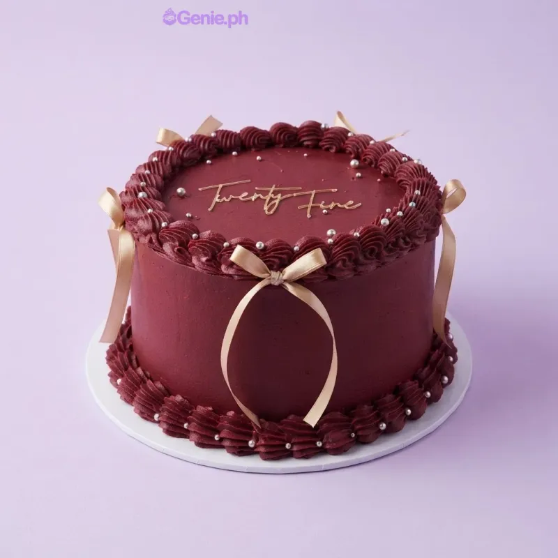 Dark red 1-tier cake with soft icing, gold script age topper, champagne ribbon bows, and silver pearl accents Dark red 1-tier cake with soft icing, gold script age topper, champagne ribbon bows, and silver pearl accents