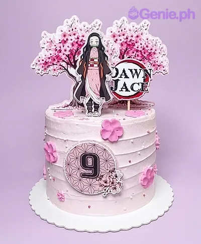 A light pink 1 tier cake featuring a Nezuko Kamado character, a cherry blossom tree backdrop, and a 'Demon Slayer' style logo with the name 'Dawn Jace', accented with pink fondant cherry blossoms and white pearl sprinkles. A light pink 1 tier cake featuring a Nezuko Kamado character, a cherry blossom tree backdrop, and a 'Demon Slayer' style logo with the name 'Dawn Jace', accented with pink fondant cherry blossoms and white pearl sprinkles.
