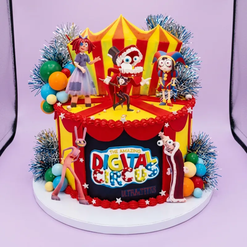 A red and yellow 1-tier cake themed around Digital Circus, featuring character printouts, a circus tent, and plastic ball decorations. A red and yellow 1-tier cake themed around Digital Circus, featuring character printouts, a circus tent, and plastic ball decorations.