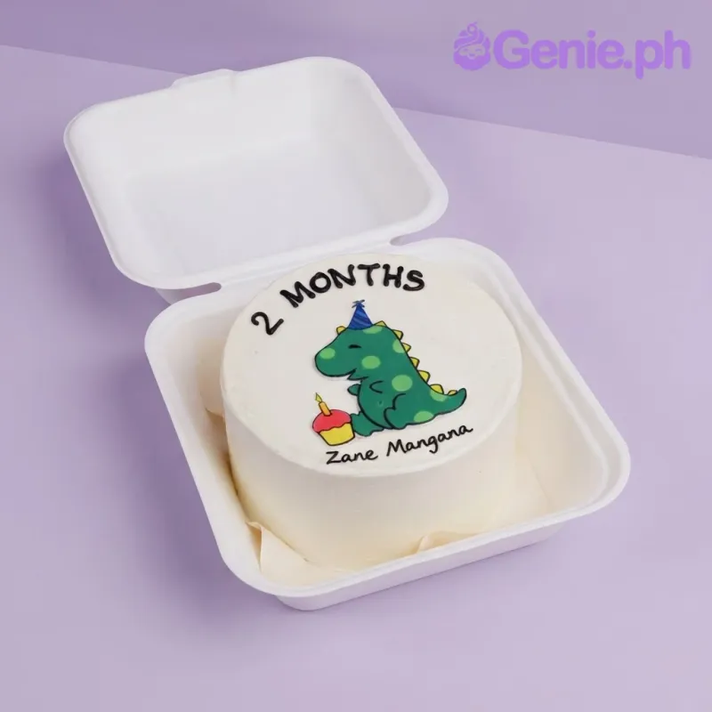 White bento cake with smooth soft icing, a green dinosaur fondant topper, and black piped lettering White bento cake with smooth soft icing, a green dinosaur fondant topper, and black piped lettering