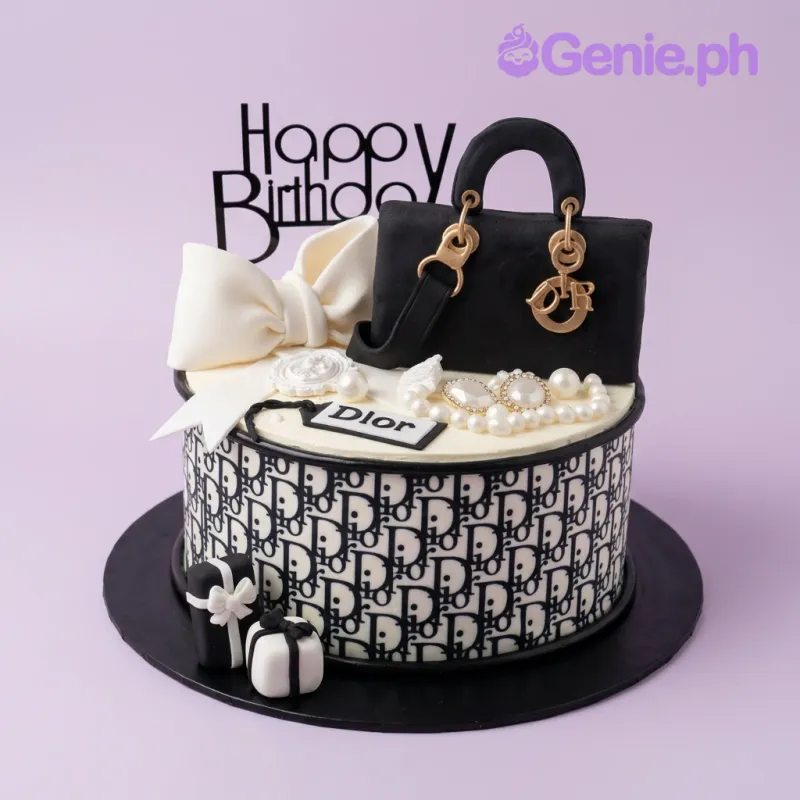 White 1-tier fondant cake with a sculpted Dior handbag, white bow, and Dior logo pattern wrap White 1-tier fondant cake with a sculpted Dior handbag, white bow, and Dior logo pattern wrap