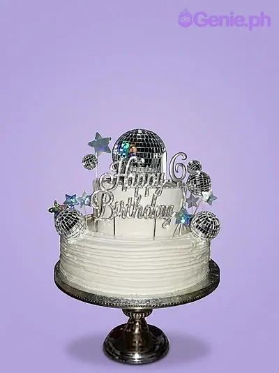 A white 2-tier Disco cake with a silver Happy Birthday topper, disco ball, 16, and holographic stars. A white 2-tier Disco cake with a silver Happy Birthday topper, disco ball, 16, and holographic stars.