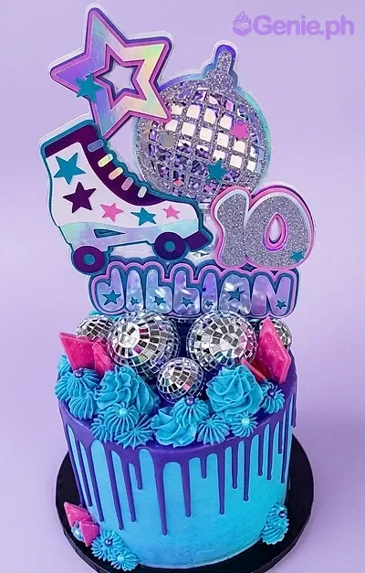 A blue and purple 1-tier Disco Roller Skate cake, featuring roller skate and disco ball toppers, with silver spheres. A blue and purple 1-tier Disco Roller Skate cake, featuring roller skate and disco ball toppers, with silver spheres.