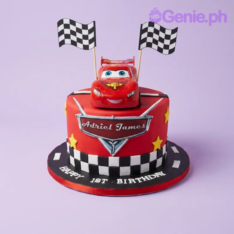 A red fondant cake themed Disney Cars, featuring a Lightning McQueen car, checkered flags, checkered border, and text. A red fondant cake themed Disney Cars, featuring a Lightning McQueen car, checkered flags, checkered border, and text.