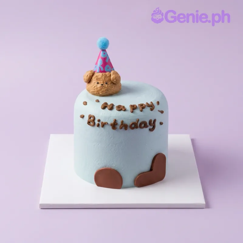 Dog Birthday cake design — 1 layer soft icing cake in light blue — with sculpted dog head with party hat, brown heart cutouts, and custom "Happy Birthday" message Dog Birthday cake design — 1 layer soft icing cake in light blue — with sculpted dog head with party hat, brown heart cutouts, and custom "Happy Birthday" message