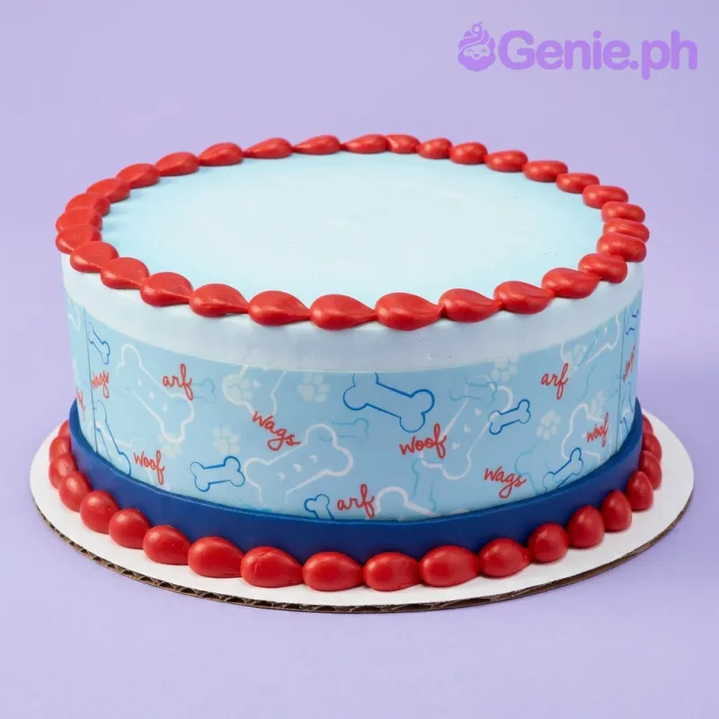 A light blue, white, and red 1-tier dog-themed cake, featuring a printed side wrap with bones and paw prints, and red icing borders. A light blue, white, and red 1-tier dog-themed cake, featuring a printed side wrap with bones and paw prints, and red icing borders.