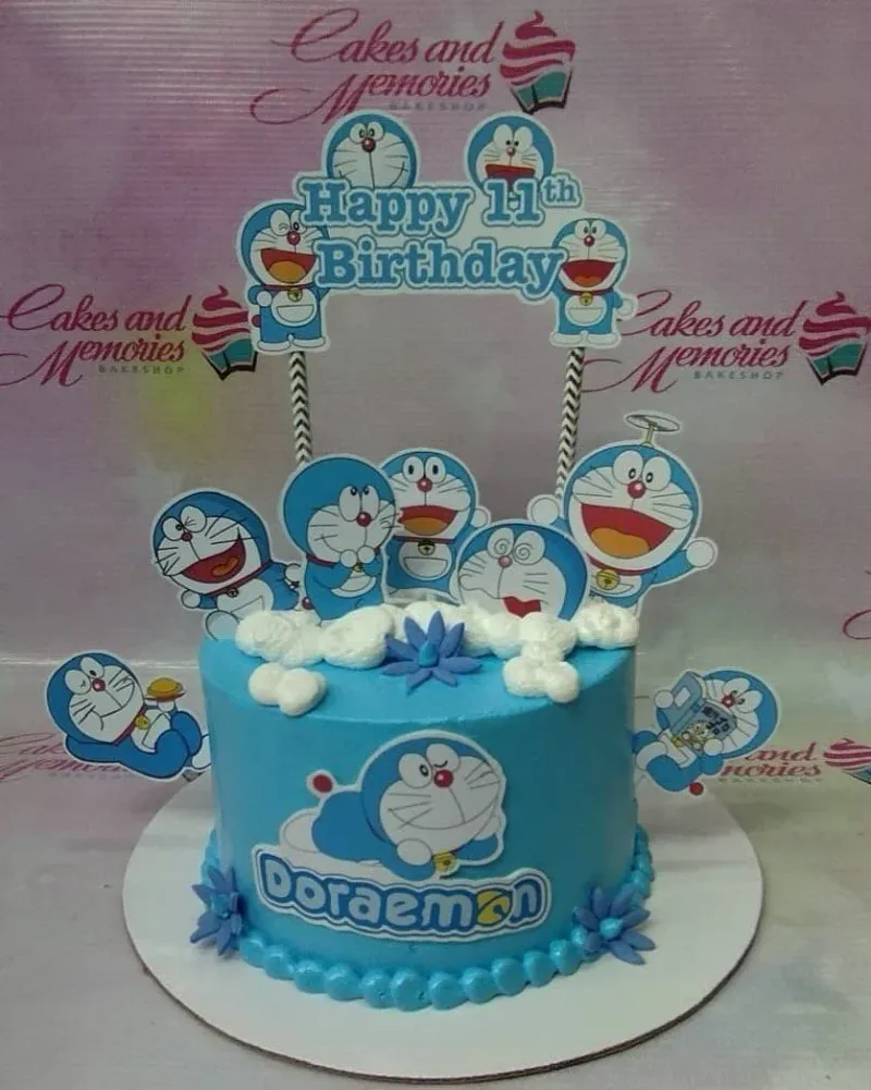A light blue 1 Tier Doraemon themed birthday cake with multiple character printouts and white icing clouds. A light blue 1 Tier Doraemon themed birthday cake with multiple character printouts and white icing clouds.