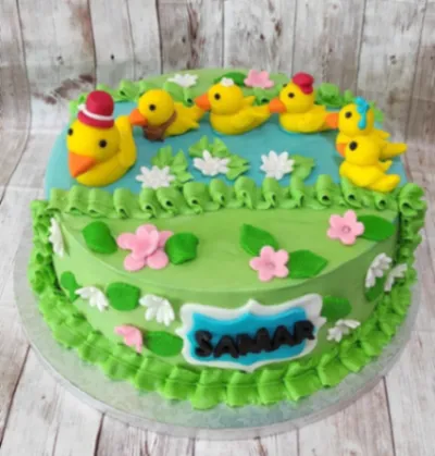 Sky blue and light green 1-tier cake with soft icing, Duck Pond Cake theme, and five yellow duck figurines Sky blue and light green 1-tier cake with soft icing, Duck Pond Cake theme, and five yellow duck figurines