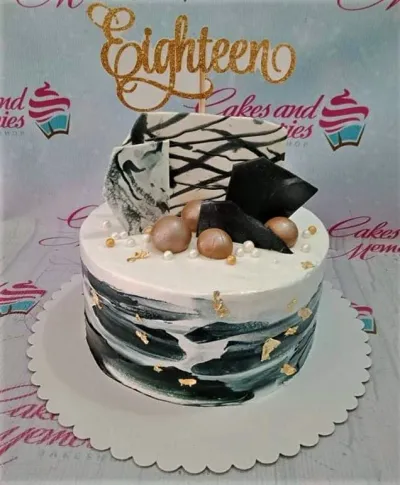 White and black marble effect cake with gold leaf accents, chocolate shards, and a gold glitter eighteen topper. White and black marble effect cake with gold leaf accents, chocolate shards, and a gold glitter eighteen topper.