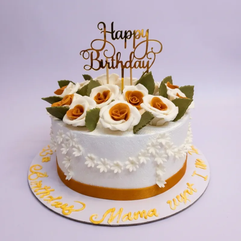 A white 1 Tier cake with orange and white gumpaste roses, green leaves, and a gold Happy Birthday topper. A white 1 Tier cake with orange and white gumpaste roses, green leaves, and a gold Happy Birthday topper.