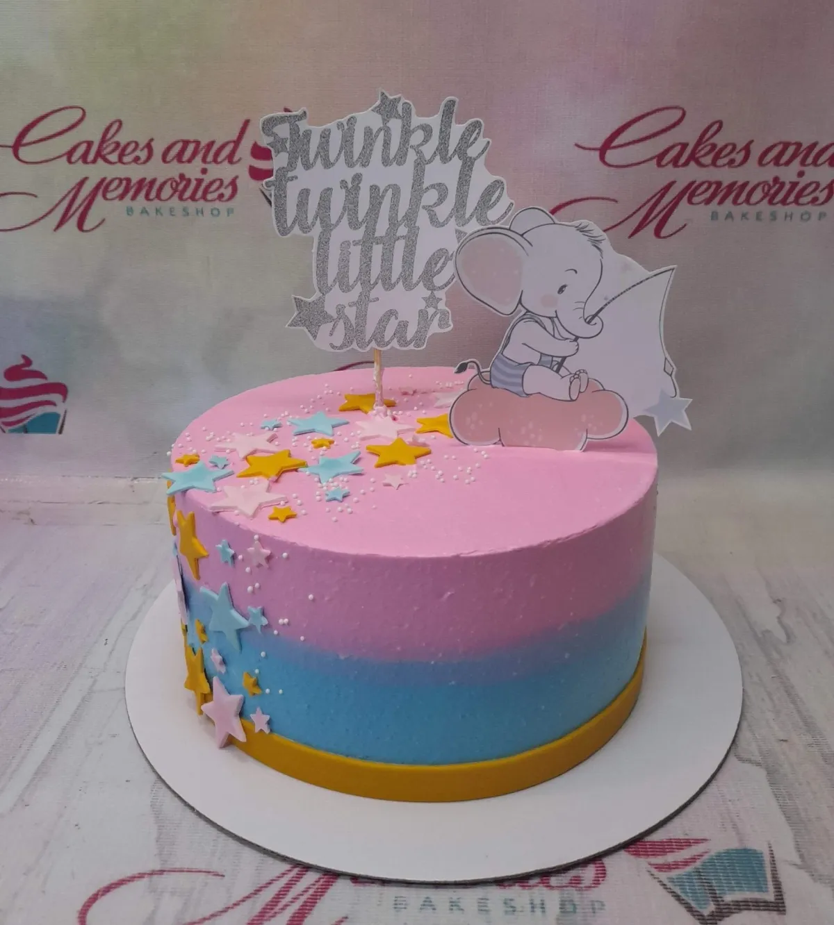 Pink and blue gradient birthday cake with an elephant topper and silver glitter Twinkle Twinkle Little Star sign. Pink and blue gradient birthday cake with an elephant topper and silver glitter Twinkle Twinkle Little Star sign.
