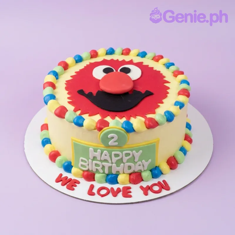 A red and light 1-Tier Elmo cake, featuring an Elmo face topper, green '2', colorful border, and a green plaque. A red and light 1-Tier Elmo cake, featuring an Elmo face topper, green '2', colorful border, and a green plaque.