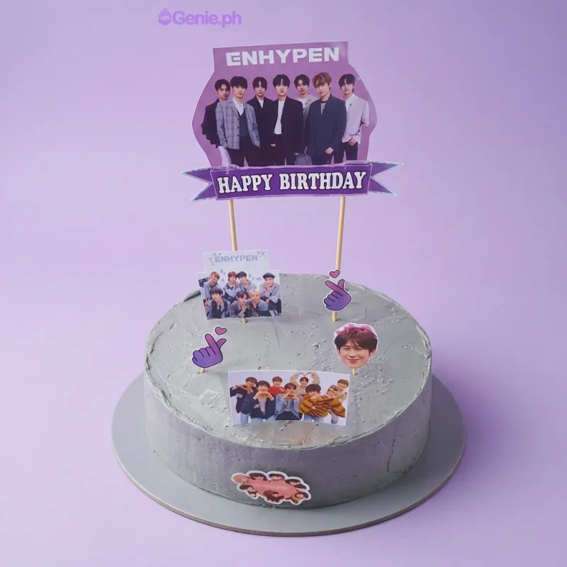 White round birthday cake with Enhypen K-pop group photo printout toppers and a heart-shaped sticker on the side White round birthday cake with Enhypen K-pop group photo printout toppers and a heart-shaped sticker on the side