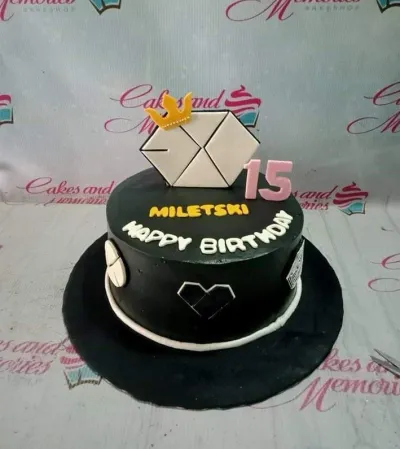 A black and white 1 Tier Fondant cake themed around EXO Kpop, featuring an EXO logo, gold crown, pink '15', and white piped borders. A black and white 1 Tier Fondant cake themed around EXO Kpop, featuring an EXO logo, gold crown, pink '15', and white piped borders.