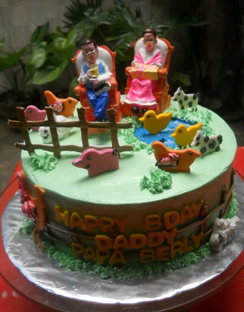 A green 1 Tier farm cake, featuring a couple in rocking chairs, fondant farm animals, and a blue pond. A green 1 Tier farm cake, featuring a couple in rocking chairs, fondant farm animals, and a blue pond.