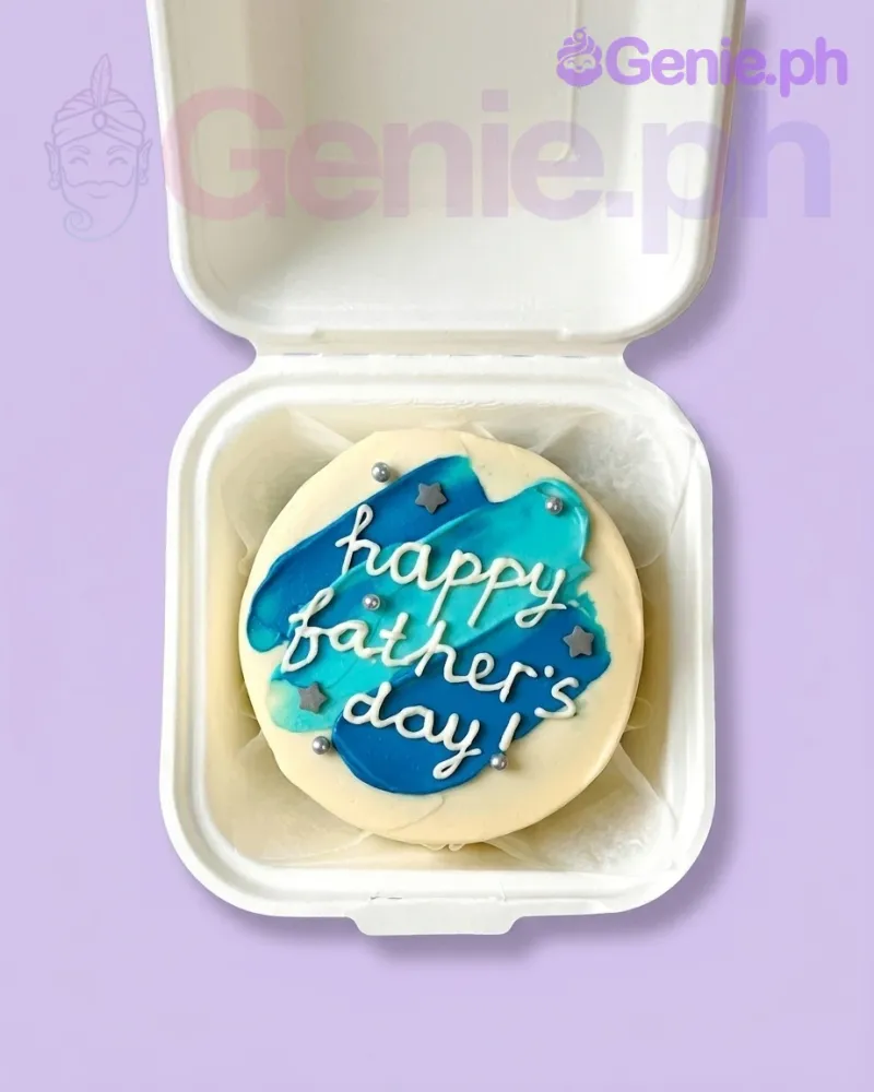 A white bento cake themed around Father's Day, featuring blue and teal palette knife icing, silver dragees, and grey fondant stars. A white bento cake themed around Father's Day, featuring blue and teal palette knife icing, silver dragees, and grey fondant stars.