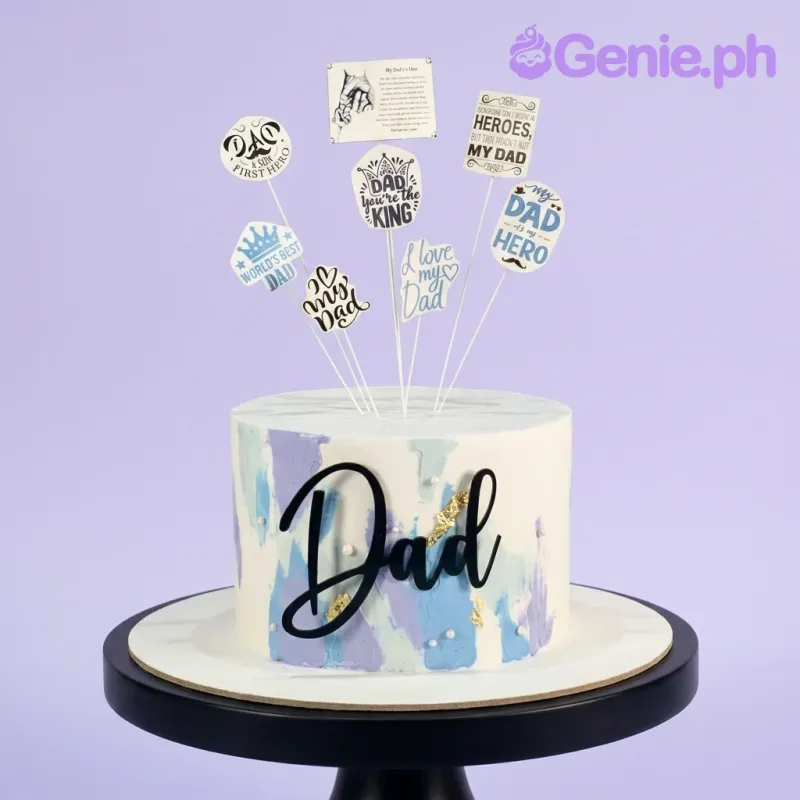 White 1-tier Father's Day cake with blue and purple palette knife icing, gold leaf accents, and multiple printed message toppers. White 1-tier Father's Day cake with blue and purple palette knife icing, gold leaf accents, and multiple printed message toppers.