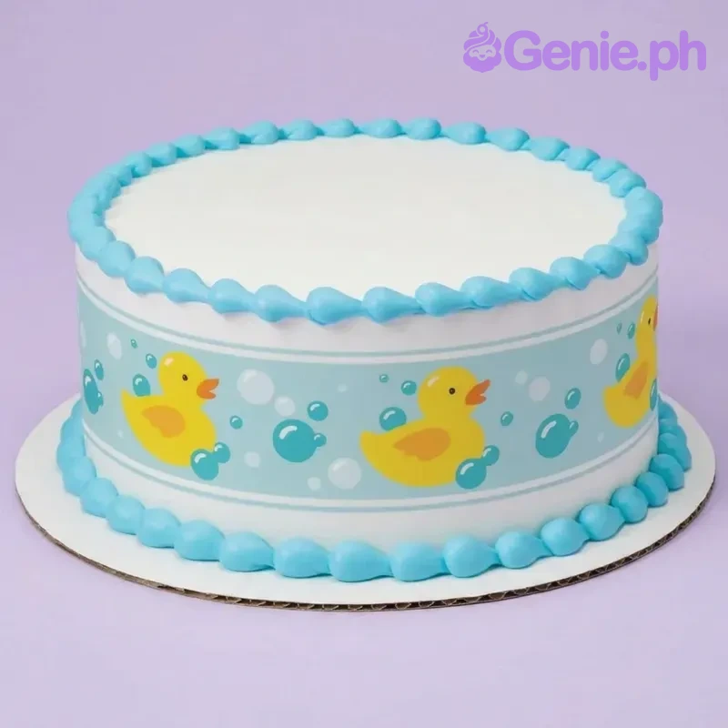 Rubber Duck White Cake A white and blue round 1-tier Rubber Duck cake, featuring an edible side wrap with yellow ducks and blue teardrop icing borders.