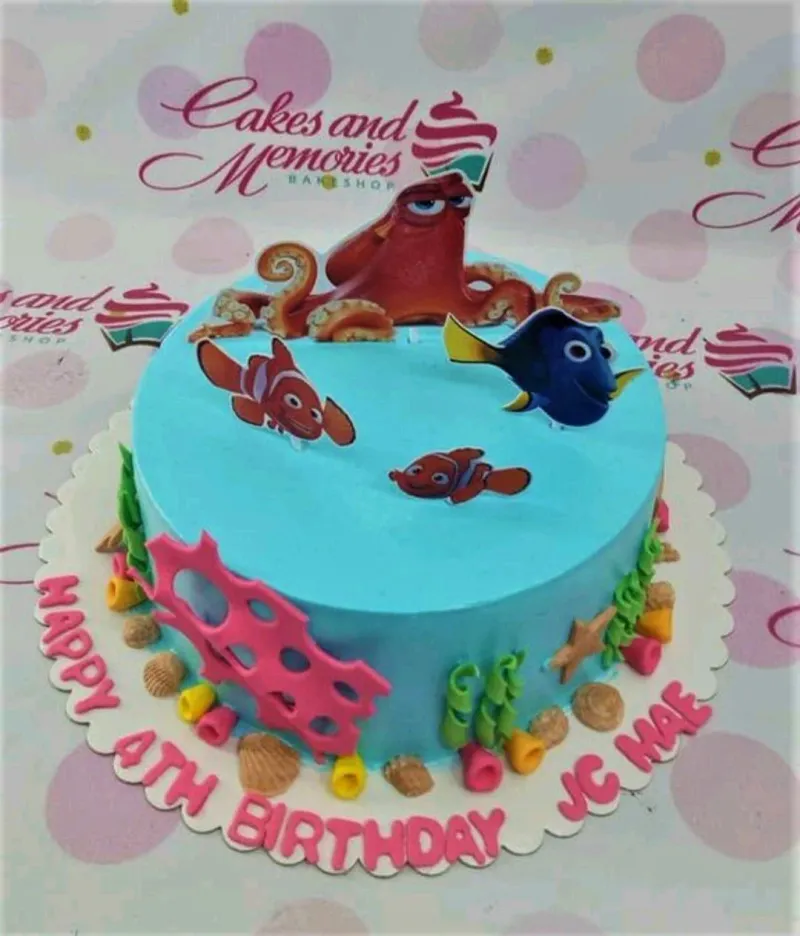 Light blue Finding Dory themed birthday cake with character printouts and colorful fondant coral reef decorations. Light blue Finding Dory themed birthday cake with character printouts and colorful fondant coral reef decorations.