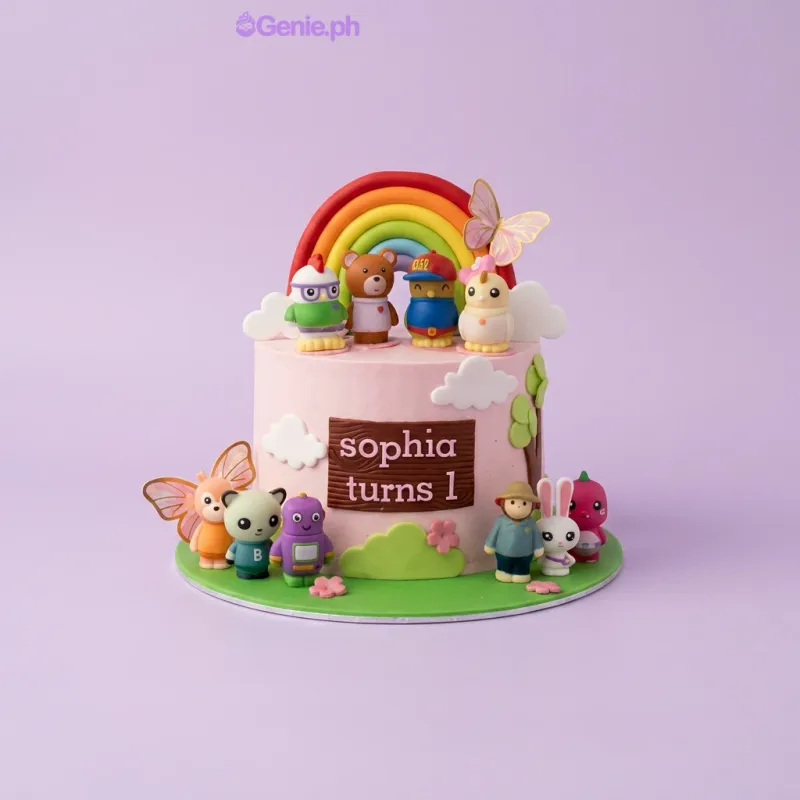 Pink 1-tier birthday cake with rainbow, character toys, and Sophia turns 1 printout Pink 1-tier birthday cake with rainbow, character toys, and Sophia turns 1 printout