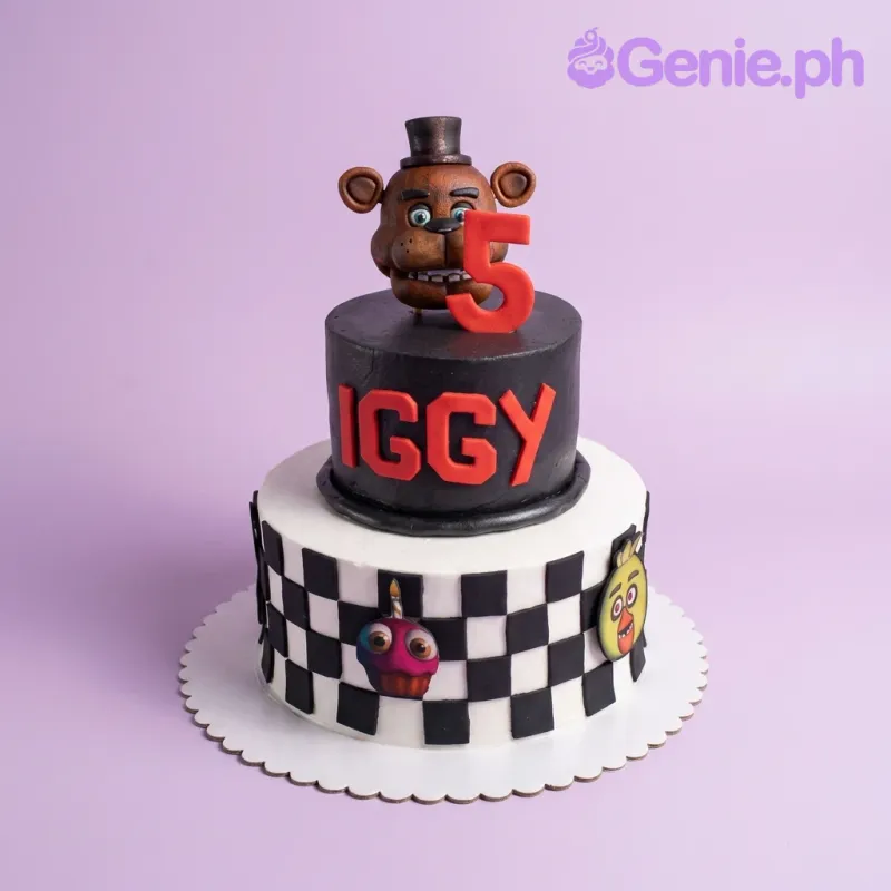 A black and white two-tier fondant cake themed around Five Nights At Freddy's, featuring Freddy Fazbear, a red number 5, and character printouts. A black and white two-tier fondant cake themed around Five Nights At Freddy's, featuring Freddy Fazbear, a red number 5, and character printouts.