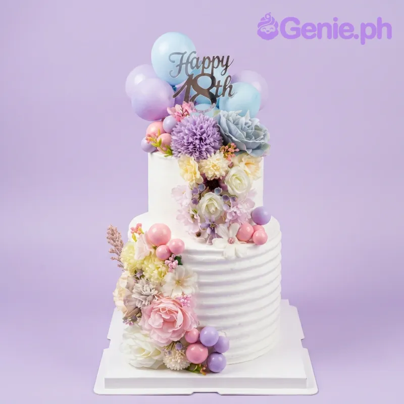 White 2-tier floral birthday cake with purple and pink artificial flowers, gold 18th topper, and pink plastic balls. White 2-tier floral birthday cake with purple and pink artificial flowers, gold 18th topper, and pink plastic balls.