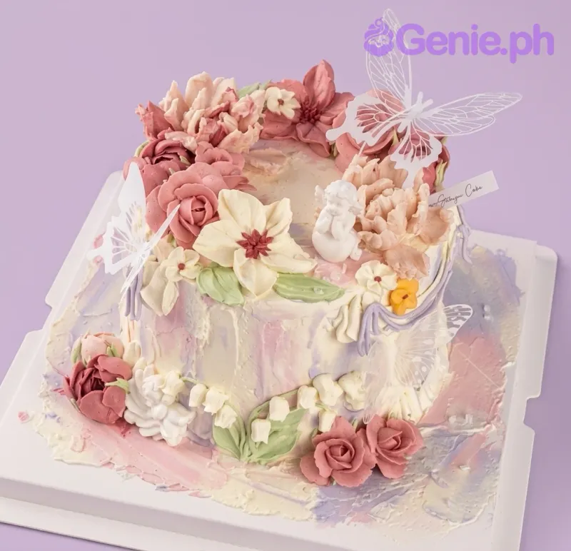 A white and pink 1-tier Floral Angel cake with an angel figurine, white butterflies, icing flowers. A white and pink 1-tier Floral Angel cake with an angel figurine, white butterflies, icing flowers.