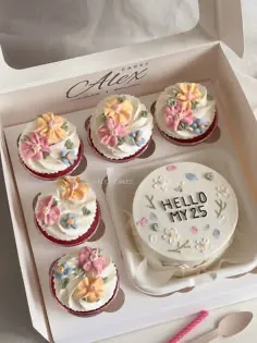 White bento and five cupcakes in a gift box decorated with colorful edible flower clusters and black piped message White bento and five cupcakes in a gift box decorated with colorful edible flower clusters and black piped message
