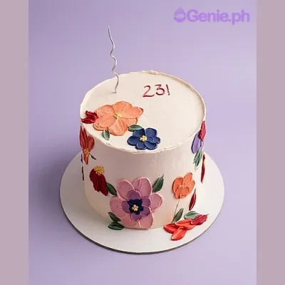 Ivory single-tier cake with piped floral icing decorations and a silver spiral candle for a 23rd birthday Ivory single-tier cake with piped floral icing decorations and a silver spiral candle for a 23rd birthday