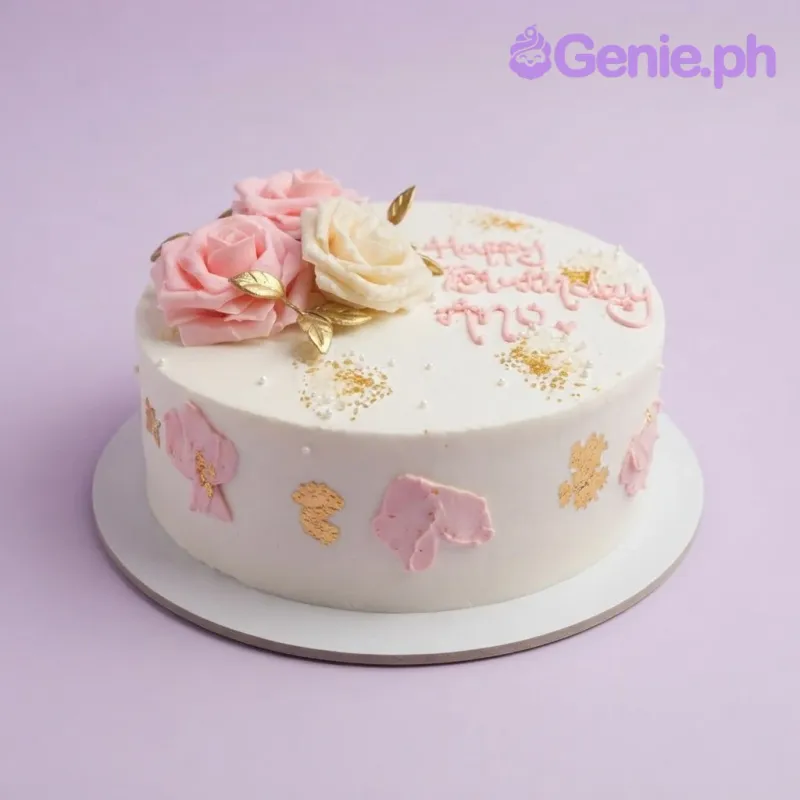 White 1-tier cake with soft icing, floral birthday theme, three edible fondant roses, and gold leaf accents White 1-tier cake with soft icing, floral birthday theme, three edible fondant roses, and gold leaf accents