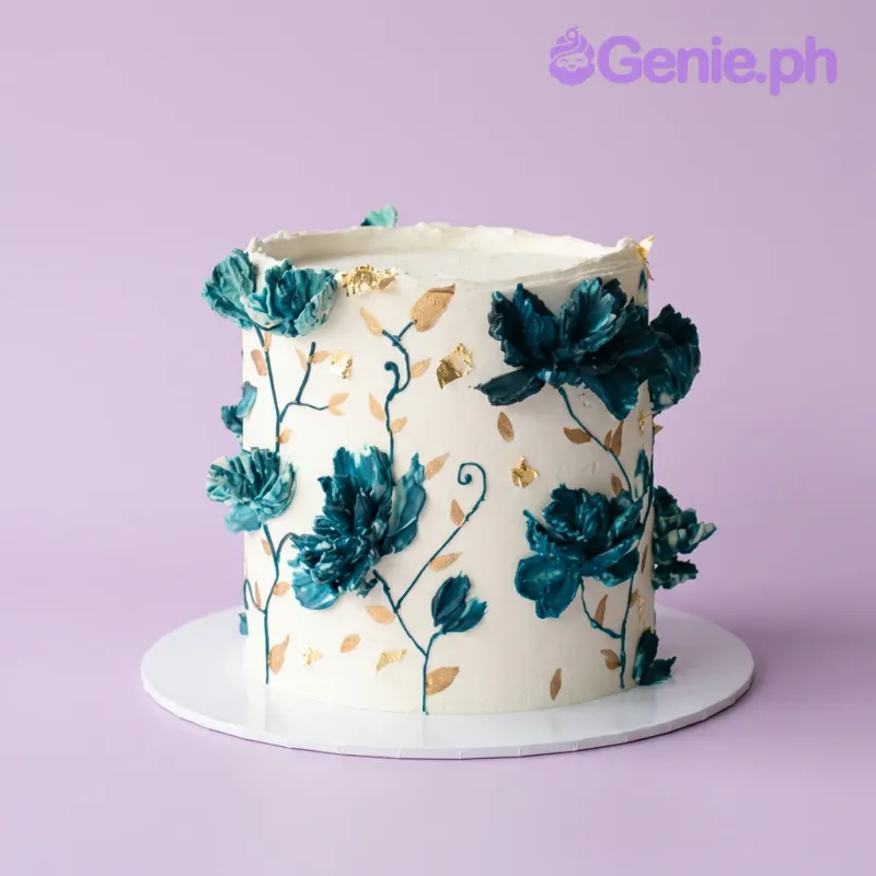 White single-tier cake with teal palette knife flowers and gold leaf accents White single-tier cake with teal palette knife flowers and gold leaf accents
